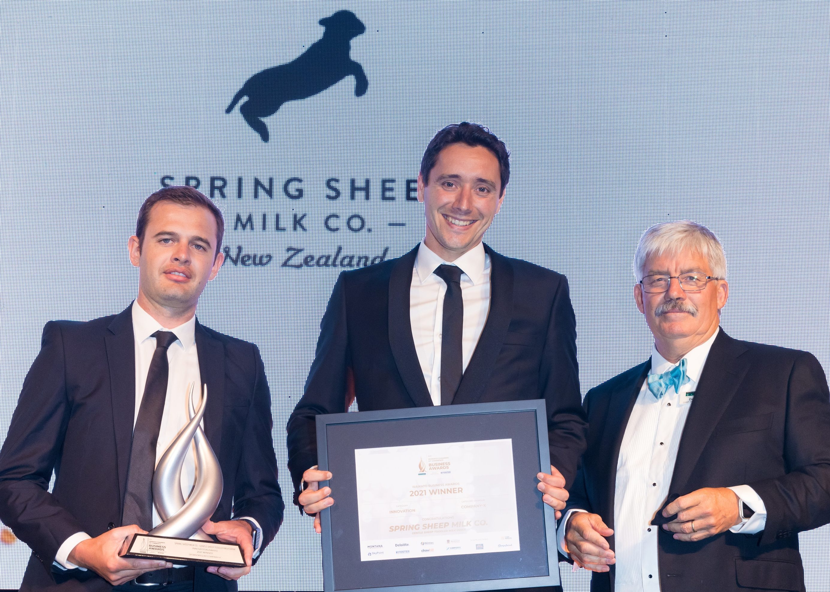 Spring Sheep Milk Co. chief executive Nick Hammond, centre, and chief operating officer Thomas Macdonald accept the Company-X Innovation Award from Waikato Chamber of Commerce chief executive Don Good.