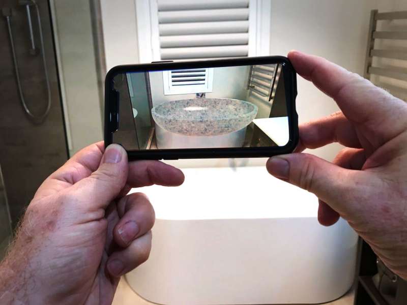 WEB BASED AUGMENTED REALITY Company X augmented reality specialist Lance Bauerfeind demonstrates how Web AR can be used to overlay a AR model of a new bath over the old bath on his smartphone